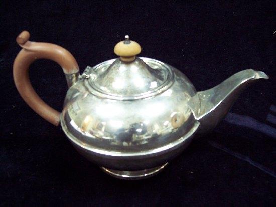 Appraisal: A circular teapot with hinged cover having a turned boxwood