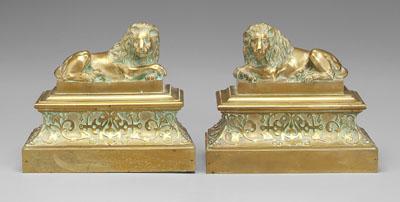 Appraisal: Pair brass chenet each with recumbent lion on stepped base