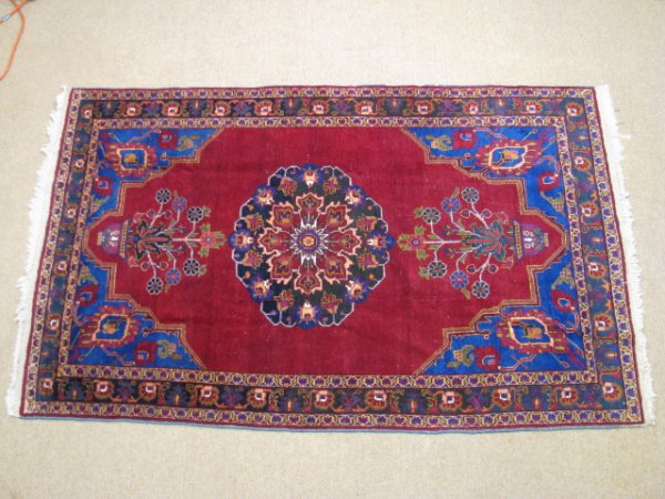 Appraisal: Persian hand knotted wool carpet with vibrant blues and burgundy