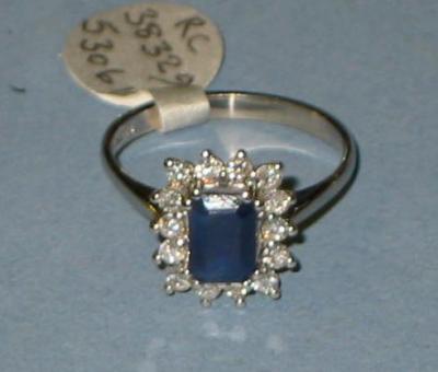 Appraisal: A SAPPHIRE AND DIAMOND CLUSTER RING the emerald-cut sapphire claw