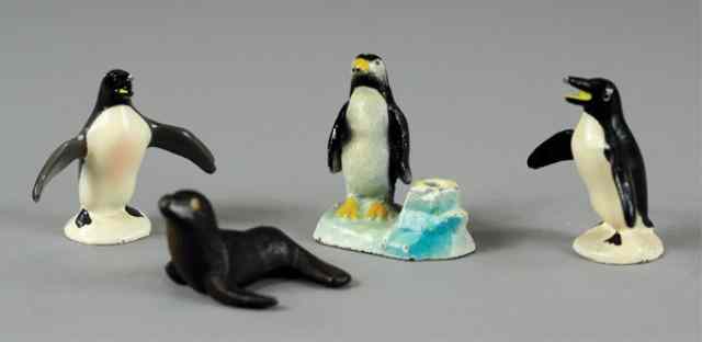 Appraisal: SEAL AND PENGUINS PAPERWEIGHTS Cast iron features penguin with pencil