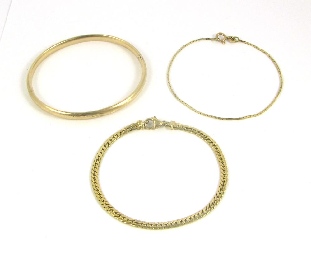 Appraisal: THREE YELLOW GOLD BRACELETS oval K gold bangle mm width