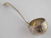 Appraisal: A silver sifter ladle the deep bowl with scrolling piercing