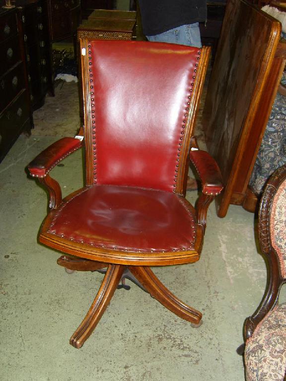 Appraisal: An Edwardian walnut framed swivel office chair with leather upholstered