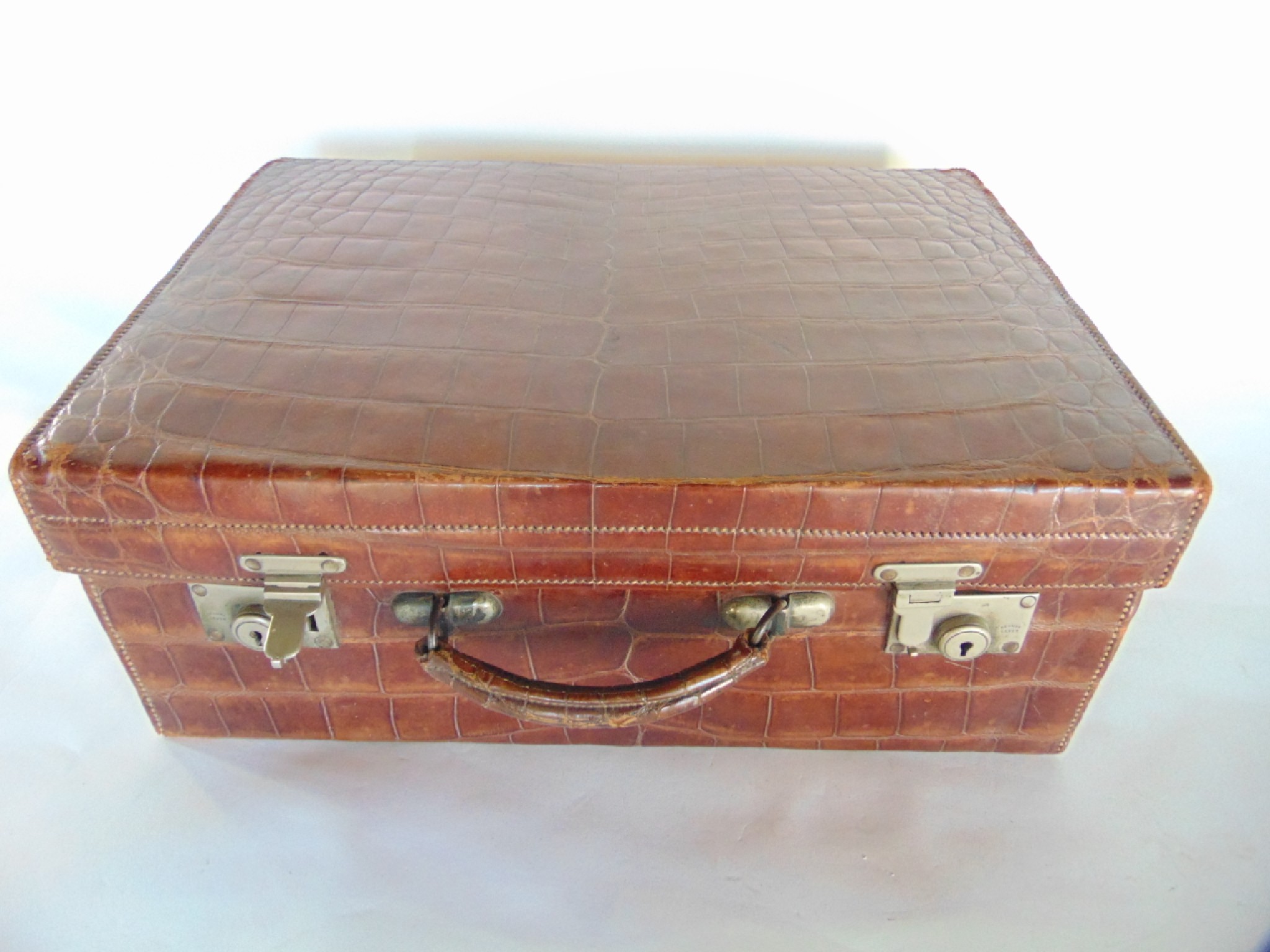 Appraisal: A good quality antique stitched and tanned crocodile leather suitcase