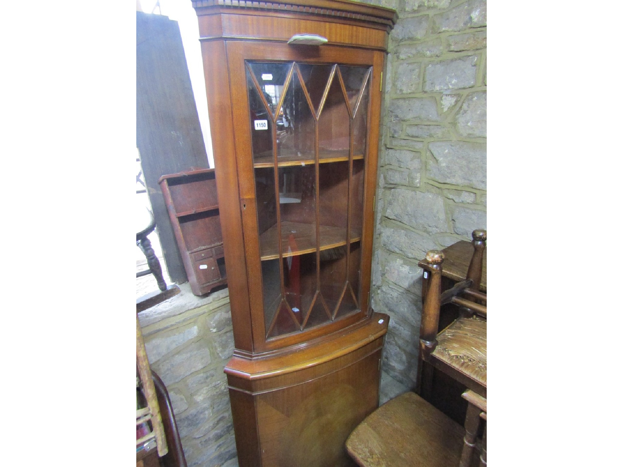 Appraisal: A reproduction mahogany freestanding and bow fronted corner cabinet in