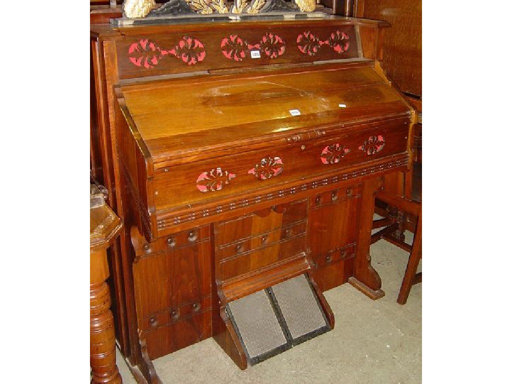 Appraisal: A late Victorian American walnut cased harmonium with decorative pierced