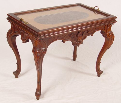 Appraisal: CARVED WALNUT TEA TABLE Removable glass tray top with detailed