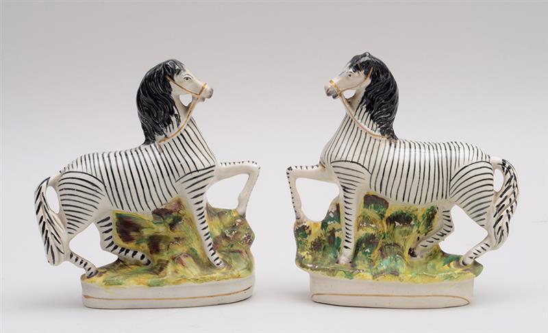 Appraisal: PAIR OF STAFFORDSHIRE POTTERY FIGURES OF ZEBRAS x x in