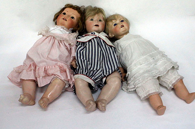 Appraisal: A GROUP OF THREE CONTEMPORARY BISQUE HEADED DOLLS the largest