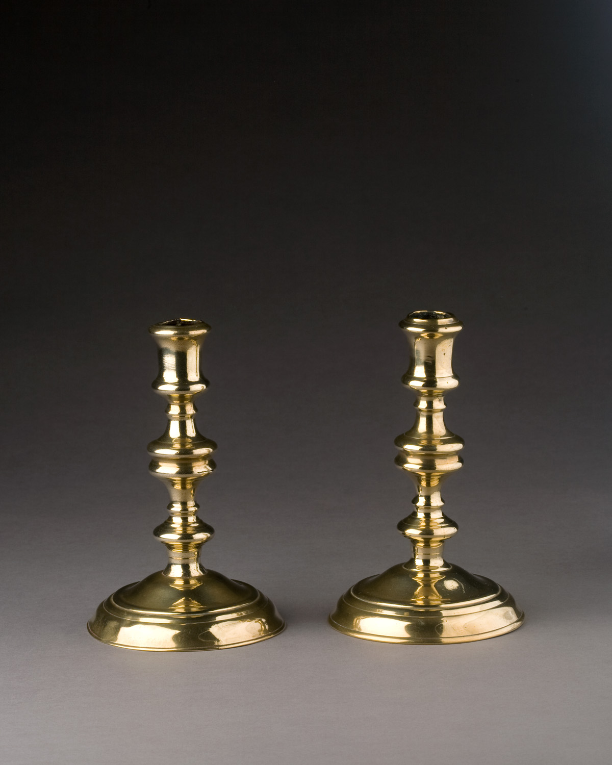 Appraisal: PAIR OF GEORGE I BRASS CANDLESTICKS CIRCA Each cylindrical nozzle