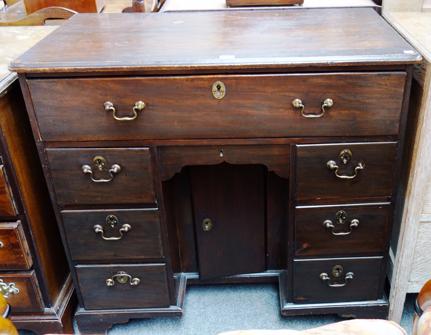 Appraisal: A George III mahogany kneehole desk with seven drawers about