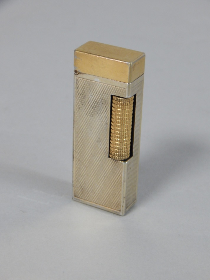 Appraisal: A Dunhill gold plated lighter with engine turned decoration