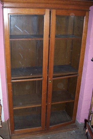 Appraisal: An oak bookcase the moulded frieze over two glazed panel