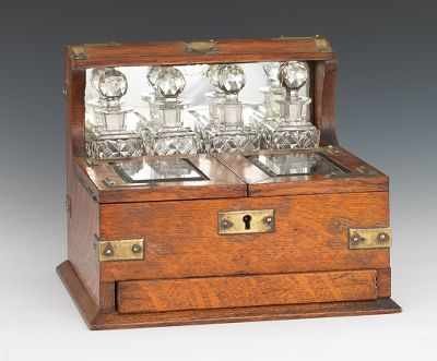 Appraisal: An Oak Tantalus Dressing Case Amber color finished oak case