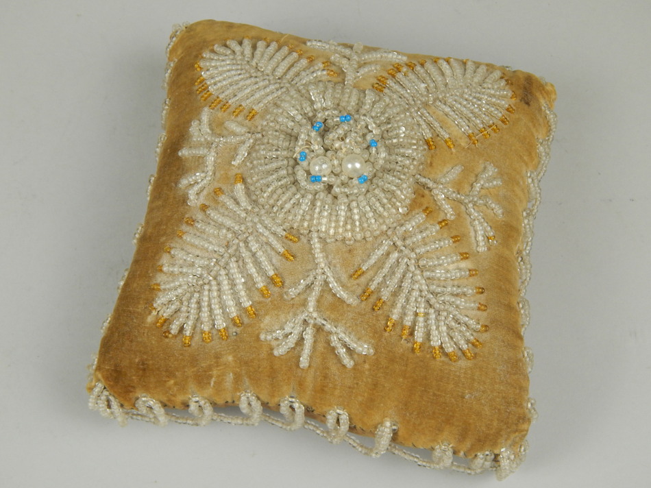 Appraisal: A Victorian square beadwork cushion decorated with leaves and stylised