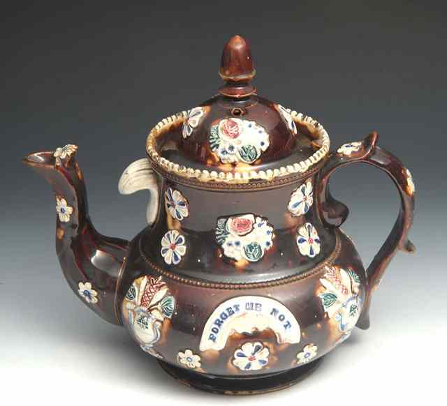 Appraisal: A VICTORIAN BROWN GLAZED BARGE WARE TEAPOT with polychrome floral