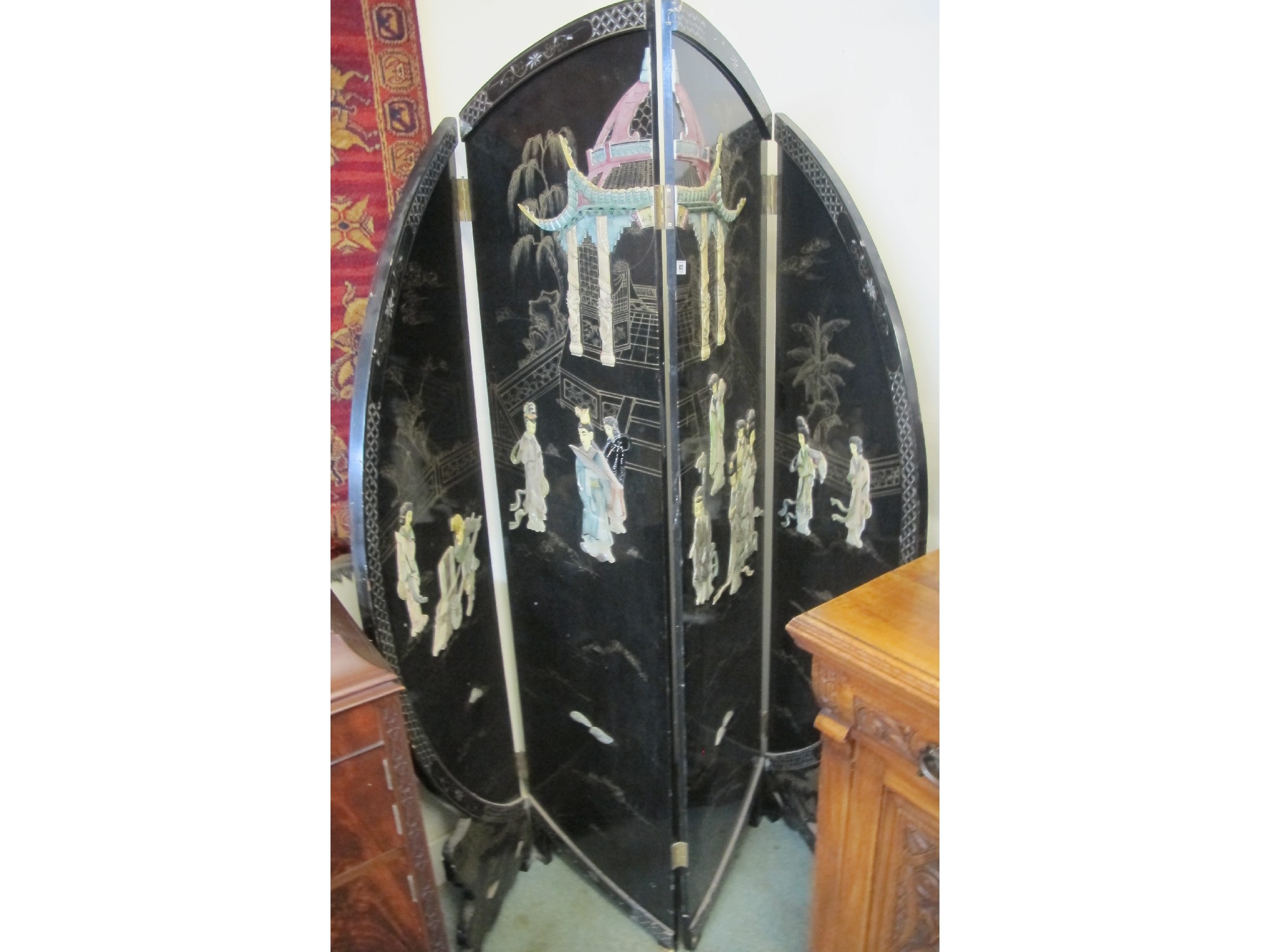 Appraisal: A four fold black lacquered screen with applied relief with