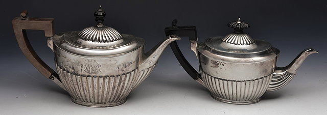 Appraisal: TWO VICTORIAN SILVER TEAPOTS of oval half lobed form one