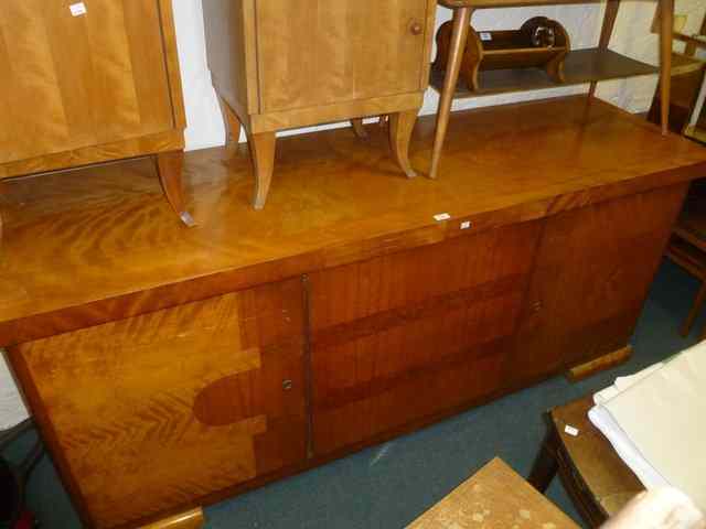 Appraisal: A SUBSTANTIAL CONTINENTAL SATIN WALNUT SIDEBOARD of stylised form fitted