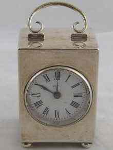 Appraisal: A silver rectangular clock on ball feet with carrying handle