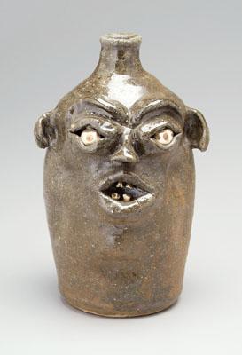 Appraisal: Stoneware face jug ceramic eyes and teeth pinched ears and