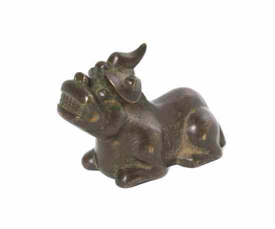 Appraisal: A Chinese Bronze Qilin Scroll Weight with silver inlay shown