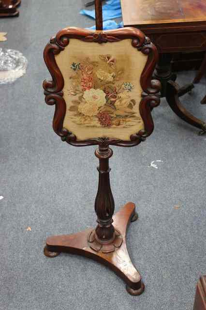 Appraisal: A VICTORIAN MAHOGANY POLE SCREEN with adjustable needlework set screen