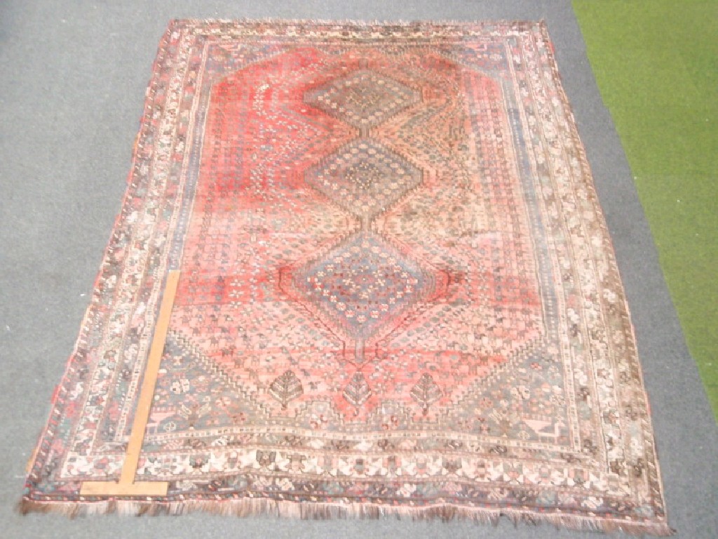 Appraisal: A red ground tri-medallion and multi-bordered rug cm x cm