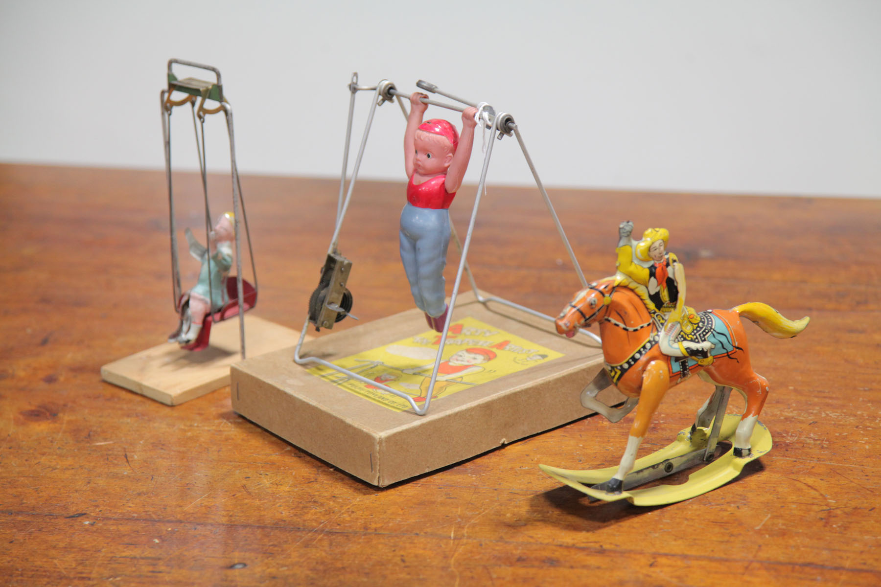 Appraisal: TWO WIND-UP TOYS AND A TIN SWING TOY American and