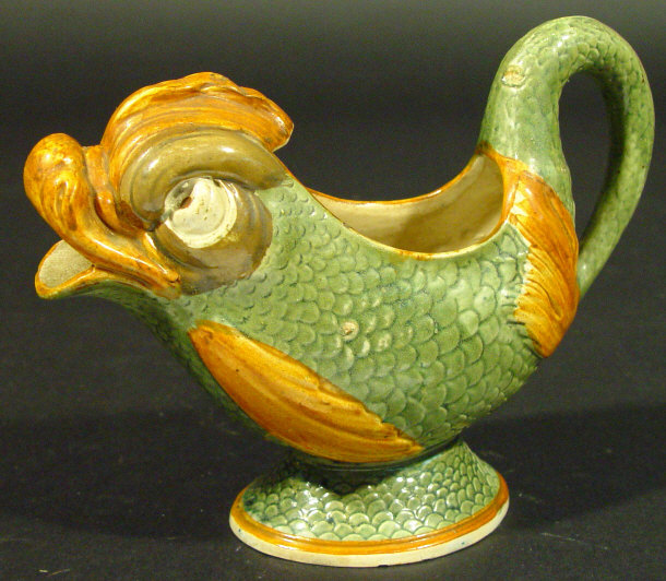 Appraisal: Continental tin glazed pottery sauceboat modelled as a green scaled