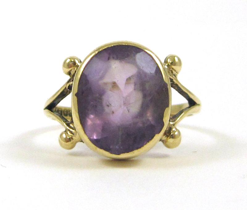 Appraisal: PURPLE GEMSTONE AND NINE KARAT GOLD RING bezel set with