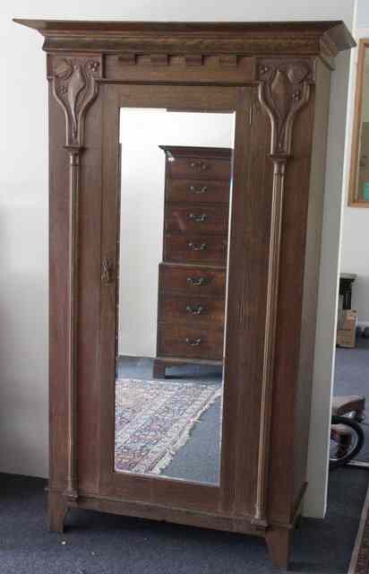 Appraisal: An Art Nouveau wardrobe carved foliate and berry capitals to