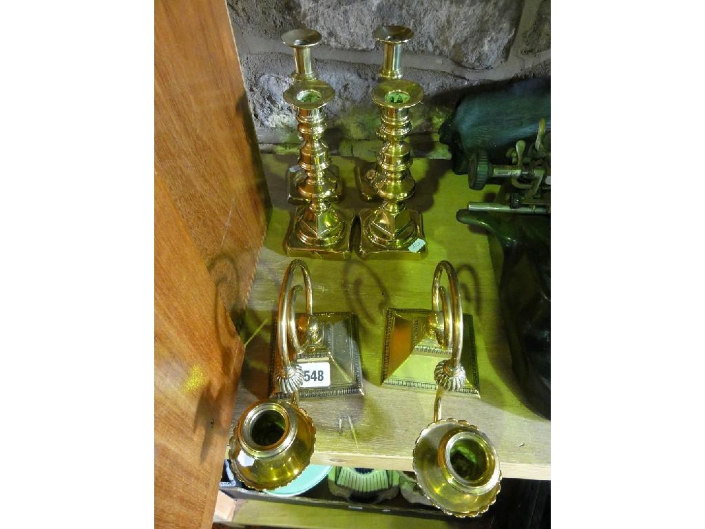 Appraisal: A pair of brass candlesticks with scrolled sconces set on