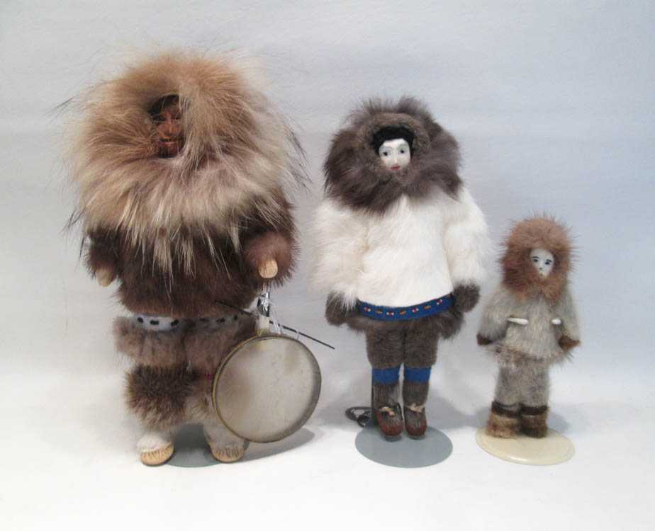 Appraisal: THREE ESKIMO DOLLS each with carved faces and fur clothing