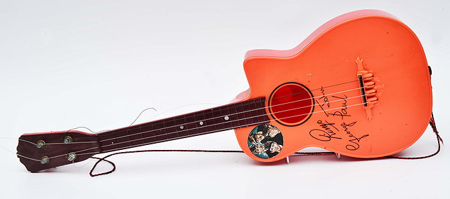 Appraisal: A RED PLASTIC BEATLES GUITAR decorated with printed signatures cm