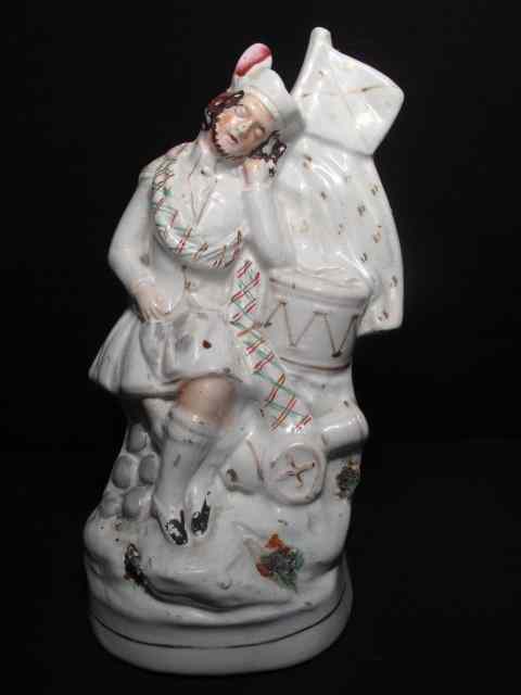 Appraisal: th century English Staffordshire figurines depicting a drummer resting Measures