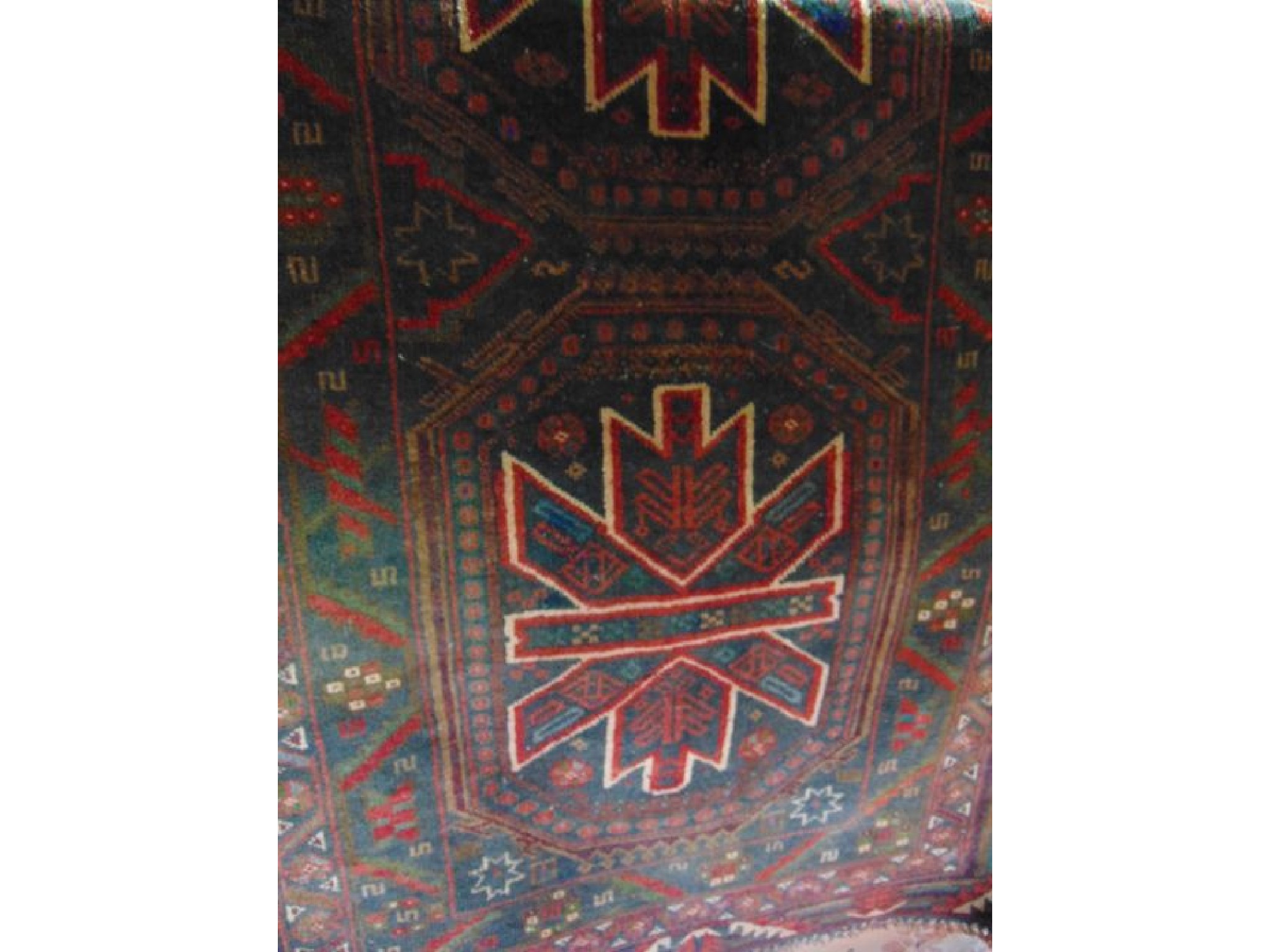 Appraisal: An Eastern wool rug with dark ground colourway double medallion