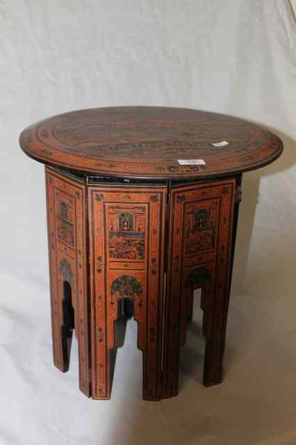 Appraisal: A BURMESE RED LACQUER CIRCULAR OCCASIONAL TABLE with ceremonial scene