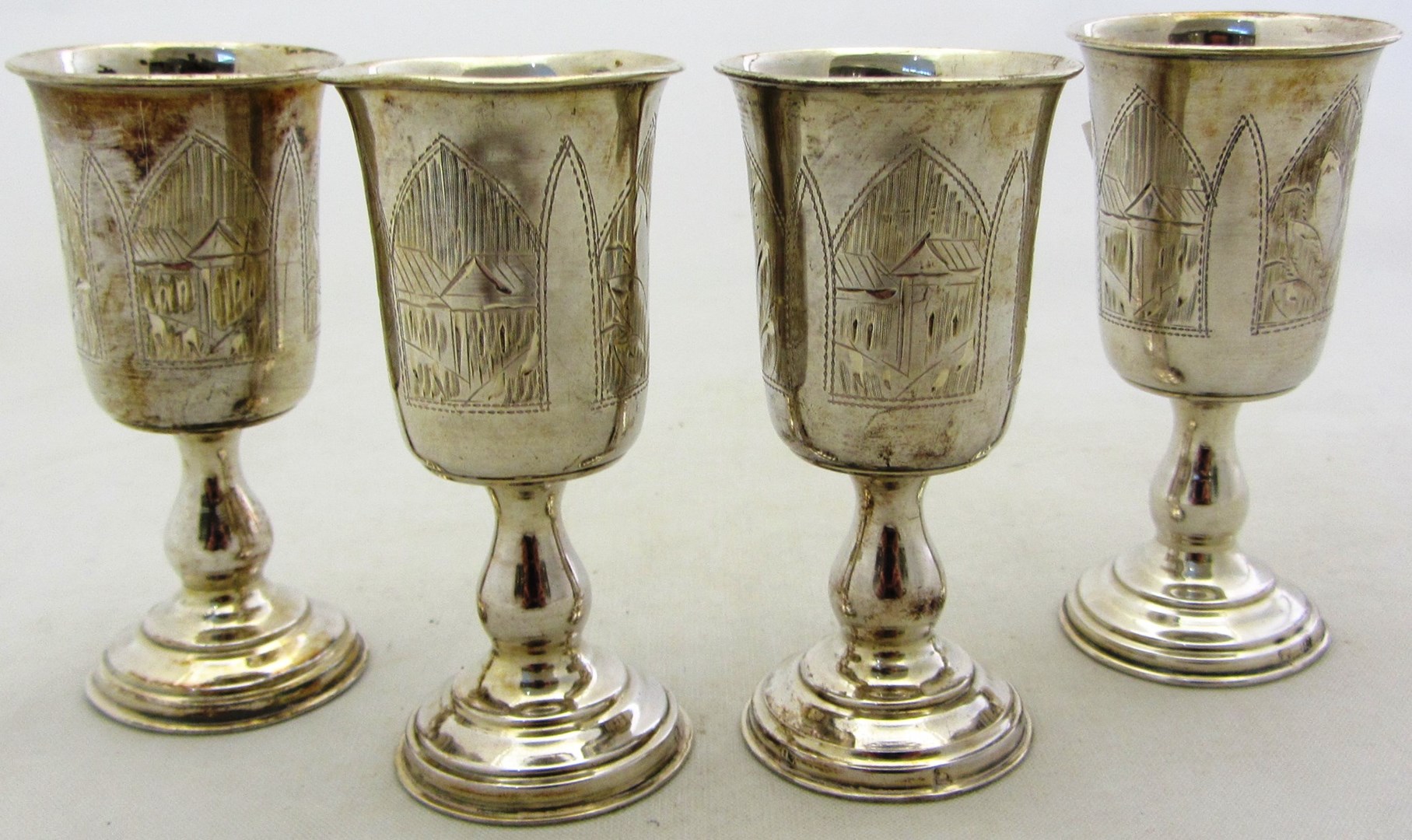 Appraisal: Four Russian Vodka goblets with engraved decoration and on circular