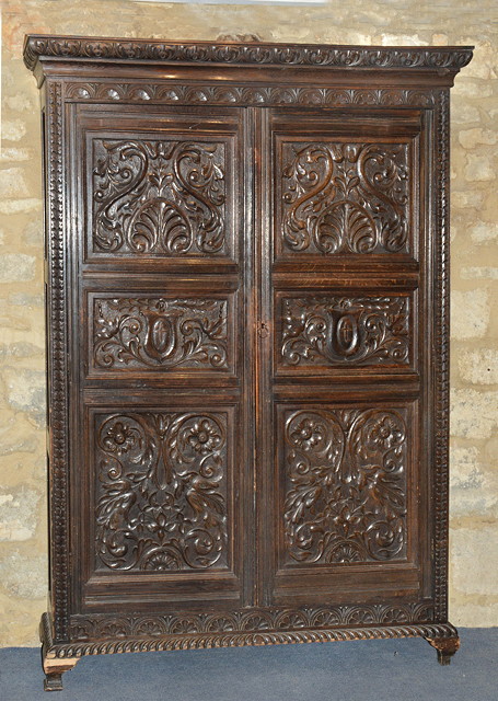 Appraisal: A FRENCH CARVED OAK HALL CUPBOARD the interior fitted shelves