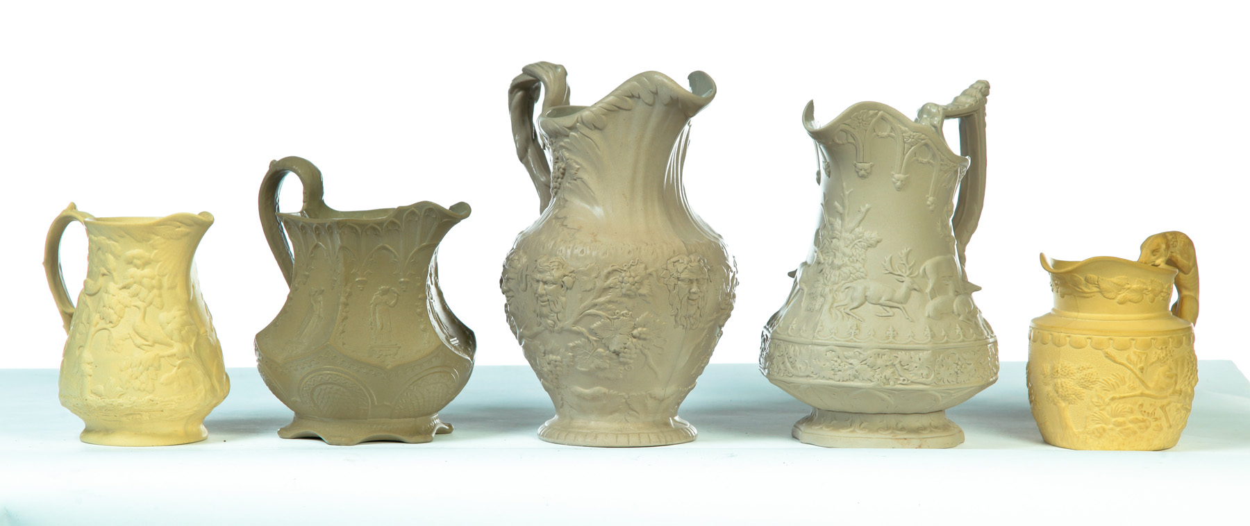 Appraisal: FIVE RELIEF MOLDED SCENIC TAN PITCHERS England mid th century