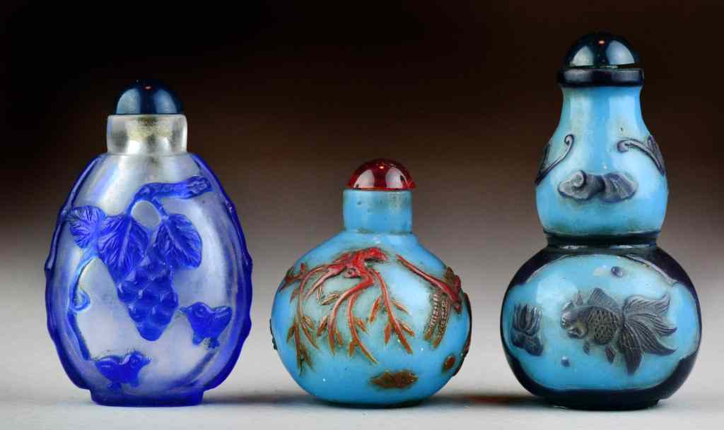 Appraisal: Chinese Peking Glass Snuff BottlesCarved to depict bats goldfish lotus