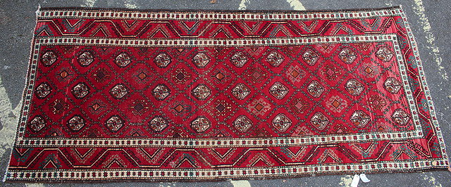 Appraisal: A TH CENTURY MIDDLE EASTERN RED GROUND RUG with central