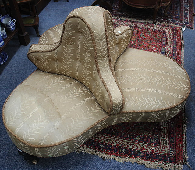 Appraisal: A VICTORIAN LOW CONVERSATION SEAT with overstuffed upholstered back and