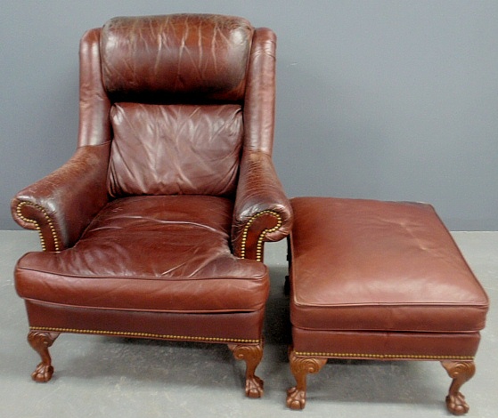 Appraisal: - Chippendale style mahogany leather wing chair and matching stool