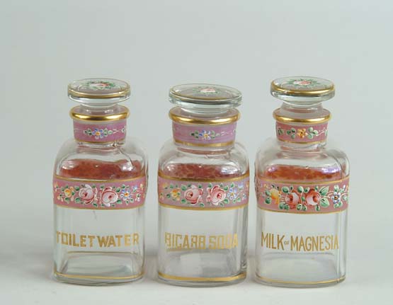 Appraisal: THREE DECORATED TOILETRY BOTTLES Each with matching flower decorated stopper