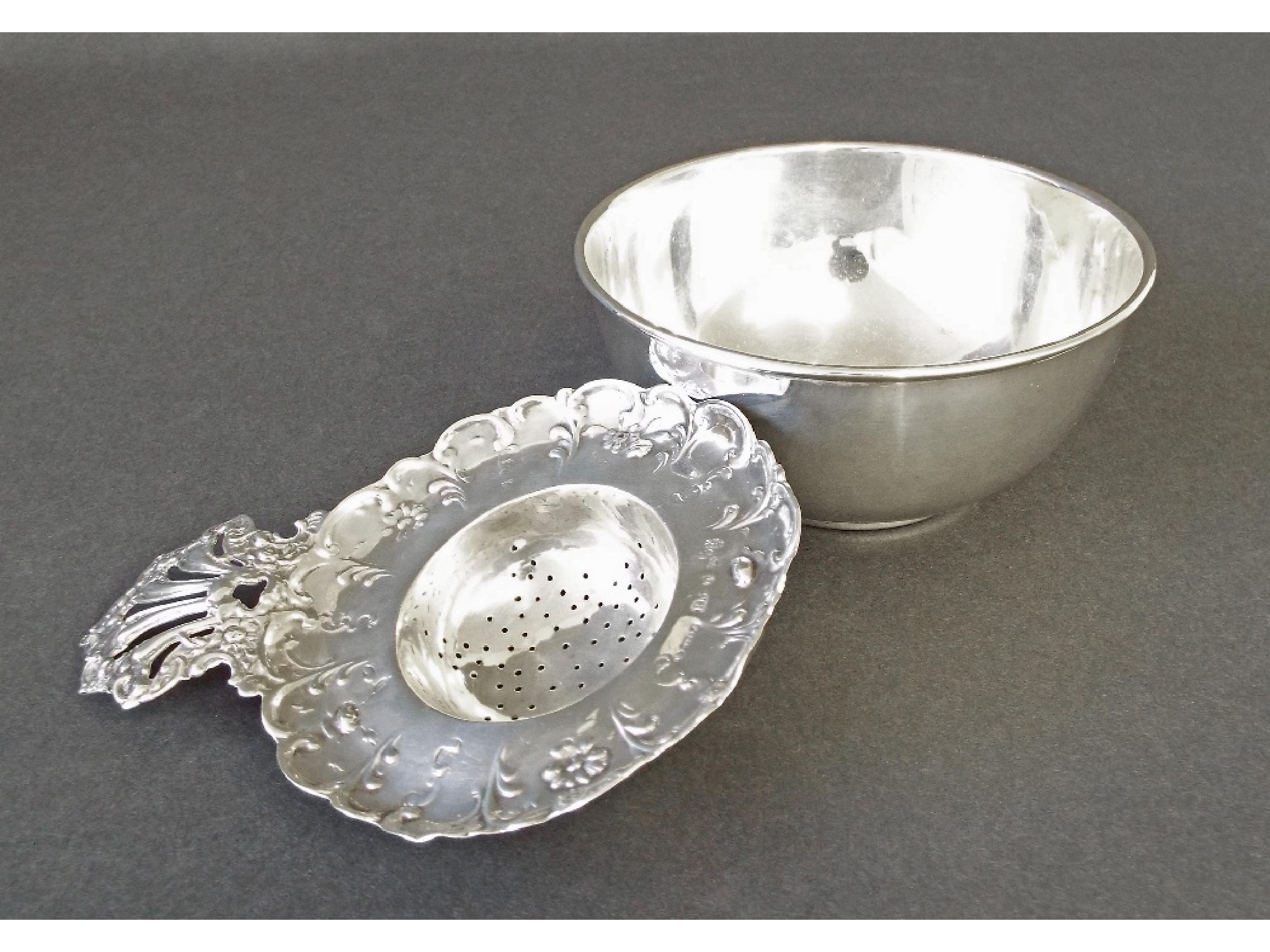 Appraisal: Continental silver strainer spoon with pierced foliate handle long together