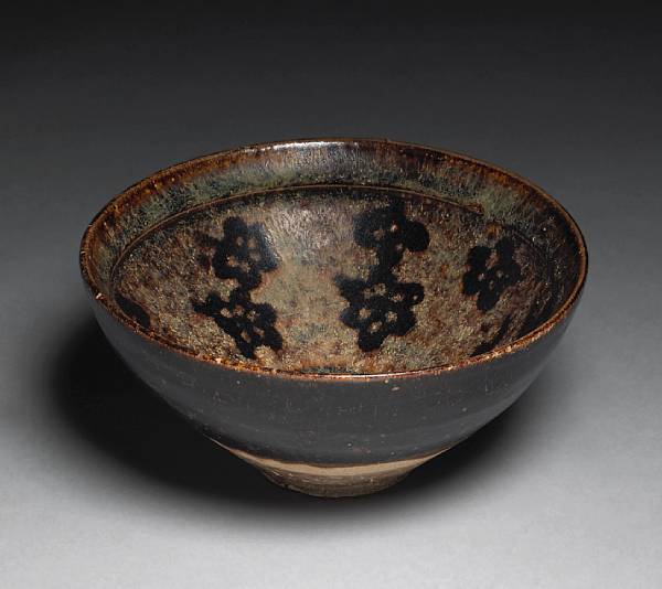 Appraisal: A Jizhou pottery tea bowl with reserve flower head decoration