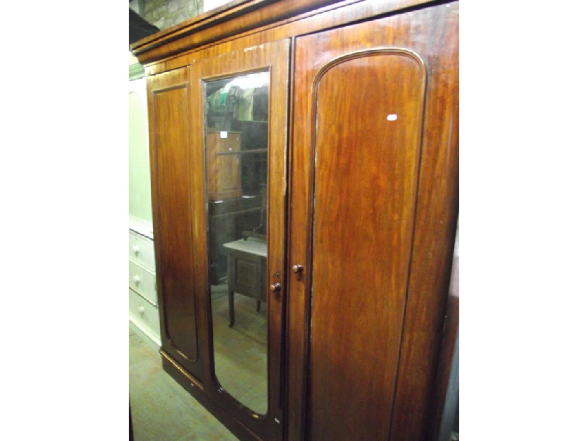 Appraisal: A Victorian mahogany triple wardrobe with moulded cornice over three